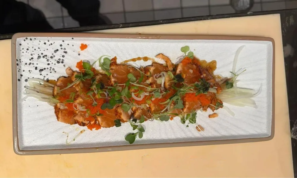 Salmon dish with greens and toppings on a plate at AKAMI Sushi & Grill,a Japanese Restaurant in Dawsonville